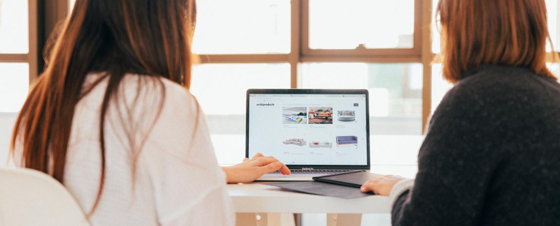 two women from behind looking at laptop